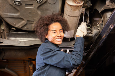 Low angle view of female mechanic inspecting car