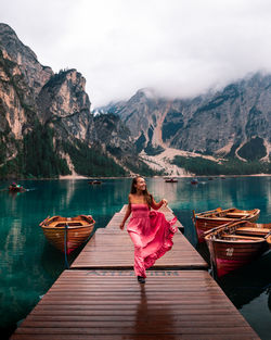 Woman on boat in lake against mountains