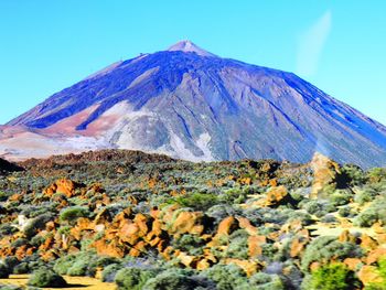 View of volcanic mountain against blue sky