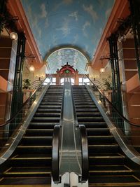 Low angle view of woman on escalator in building