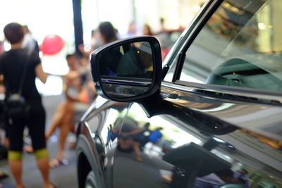 Reflection of man on side-view mirror