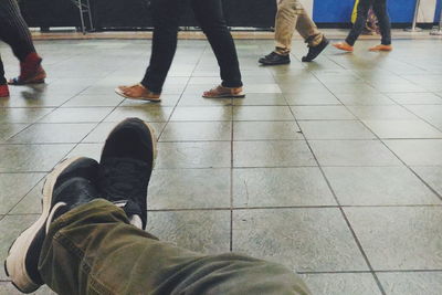 Low section of woman standing on tiled floor