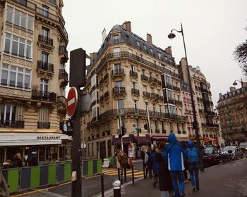 People on street amidst buildings in city