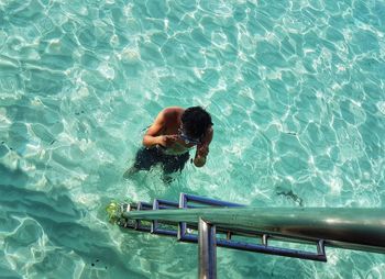 High angle view of shirtless man snorkeling in sea