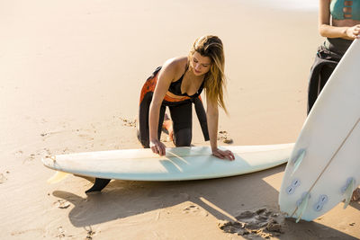 Female friends with surfboards at beach