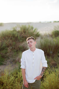 Portrait of young man standing on field