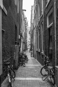 Bicycle parked on street amidst buildings in city