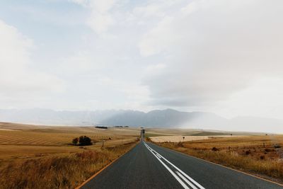 Road by landscape against sky