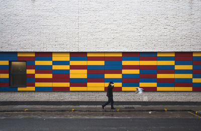 Side view of a woman standing against the wall