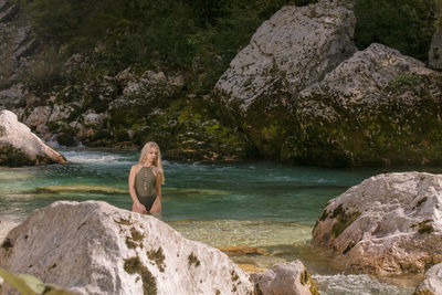 Woman standing on rocks by sea