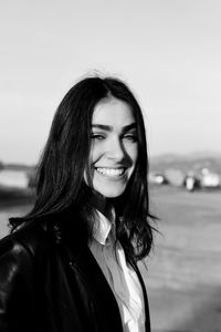 Portrait of smiling young woman against water