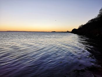 Scenic view of sea against clear sky during sunset