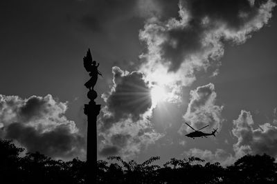 Low angle view of silhouette statue against sky
