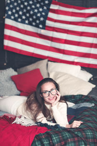 Portrait of young woman lying down on bed