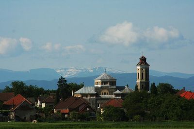 Buildings in city against cloudy sky