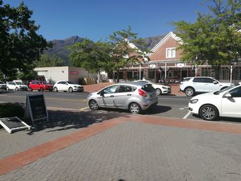 Cars on street in city against clear sky