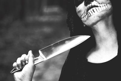 Close-up of woman in halloween make-up holding knife