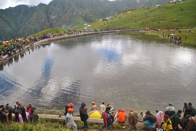 High angle view of people on shore against mountains