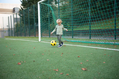 A little boy plays soccer on the soccer field