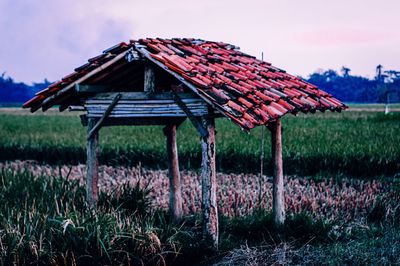 Abandoned house on field against sky