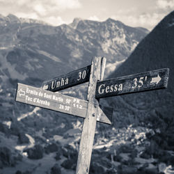 Low angle view of sign on mountain against sky