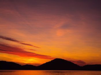 Scenic view of sea against cloudy sky during sunset