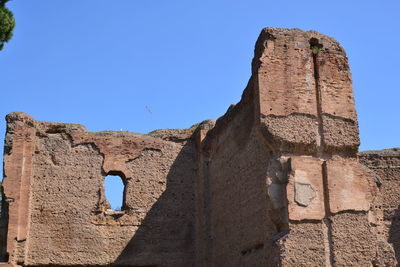 Low angle view of old ruin building against blue sky