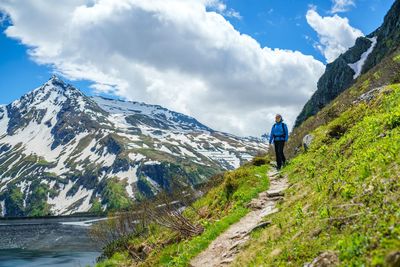 Woman hiking on footpath in the austrian alps near gastein, salzburg, austria