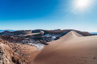 Scenic view of desert against clear blue sky