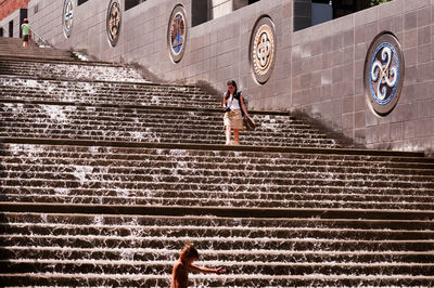 High angle view of people on staircase against wall