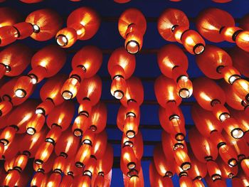 Low angle view of illuminated lighting equipment hanging on ceiling