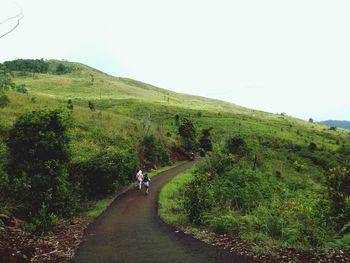 Road amidst green landscape against sky