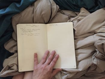 Close-up of person reading book on bed