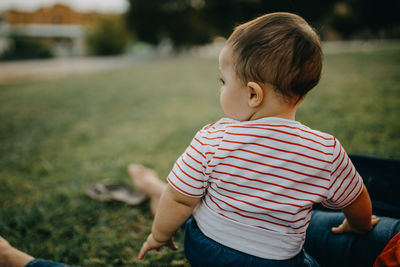 Cute boy looking away while sitting outdoors