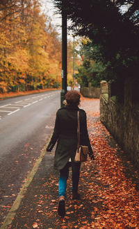 Man walking on road during autumn