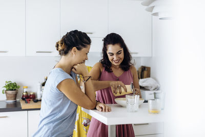Cheerful females preparing healthy meal together