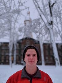 Portrait of man against bare trees during winter