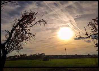 Scenic view of grassy field against cloudy sky