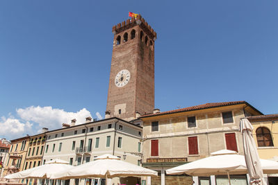 Low angle view of clock tower against blue sky