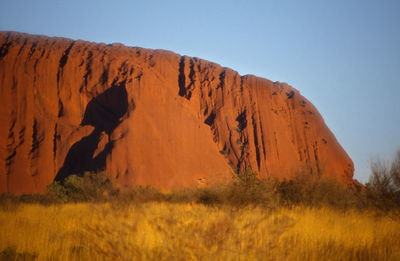 Scenic view of rocks on field against clear sky