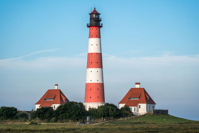 Lighthouse by sea against sky