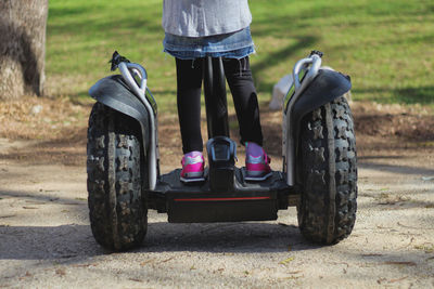 Low section of a person riding segway on footpath