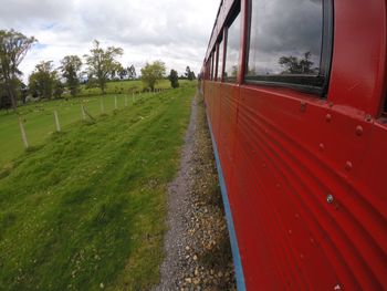 Panoramic view of railroad track amidst field against sky