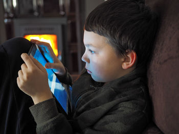 Close-up of boy using digital tablet at home