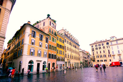 People on wet street at piazza di spagna during rainy season