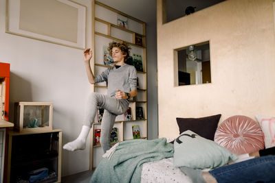 Carefree boy dancing in bedroom at home