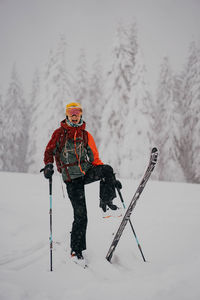Portrait of woman skiing on snow covered field