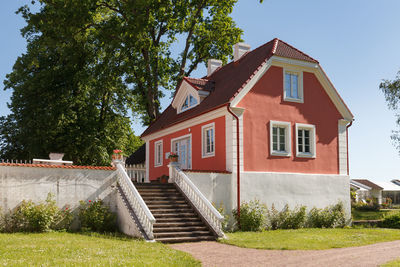 Low angle view of house by building against sky