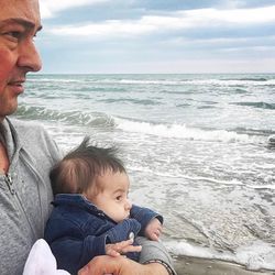 Rear view of father and son at beach