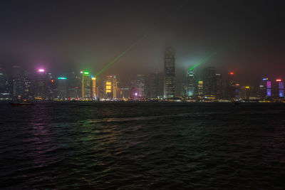 Illuminated buildings in city against sky at night